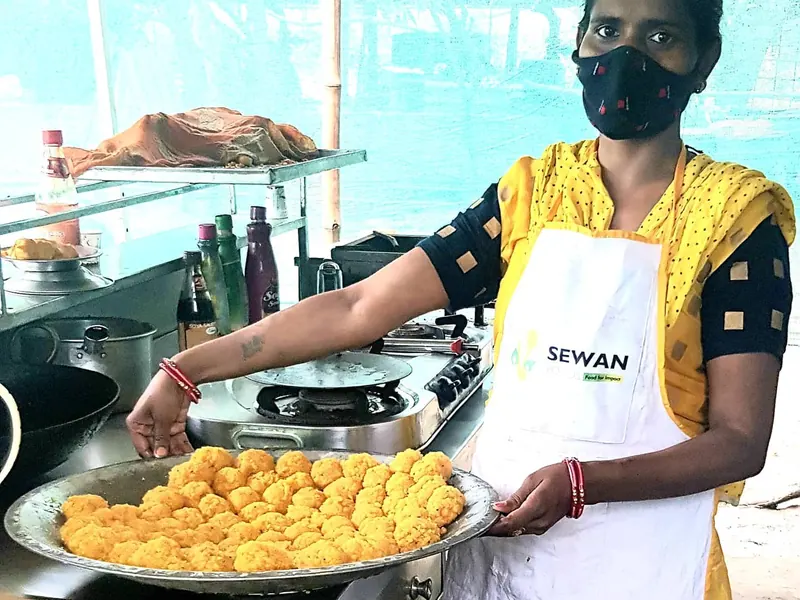 Sewan cook holding a tray of fresh pakoras