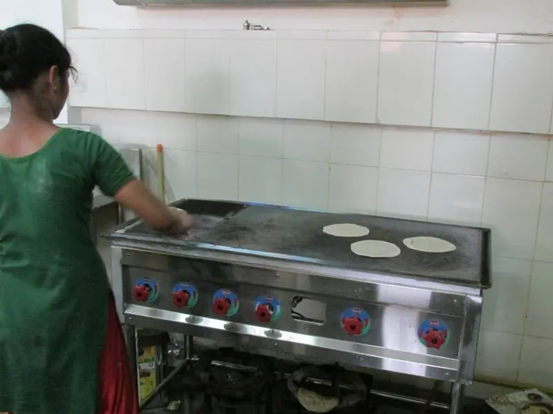 Sewan cook making rotis on a kitchen griddle