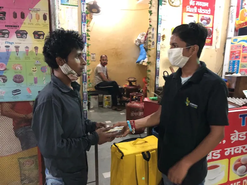 Sewan staff handing over a packed meal from a delivery bag
